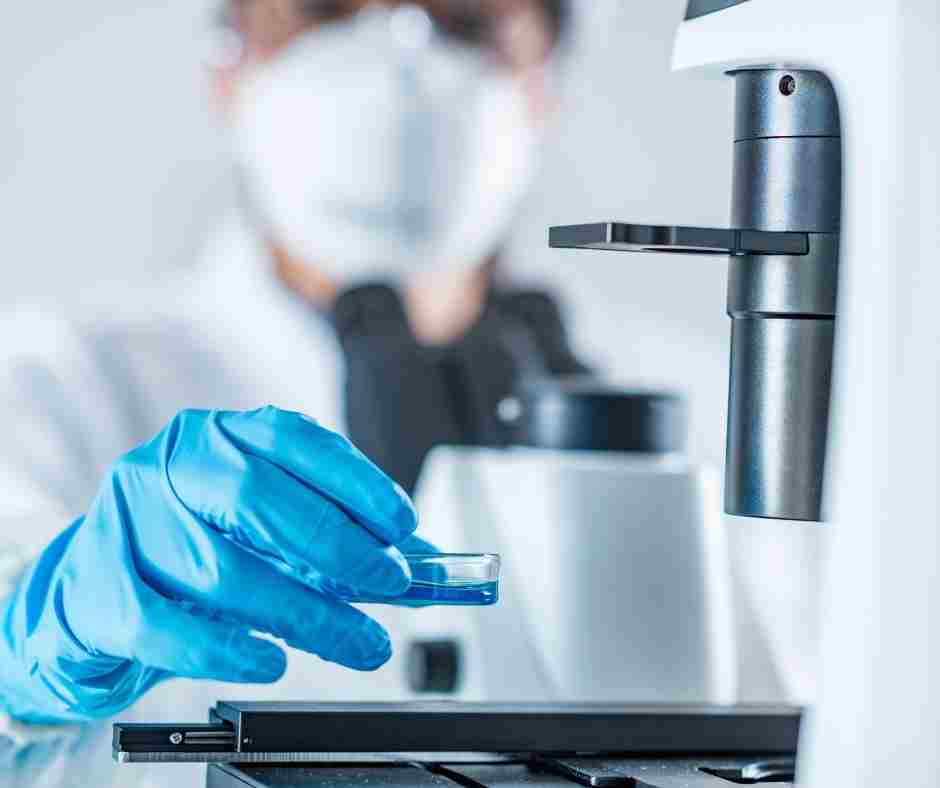 Researcher Completing An Experiment With A Microscope